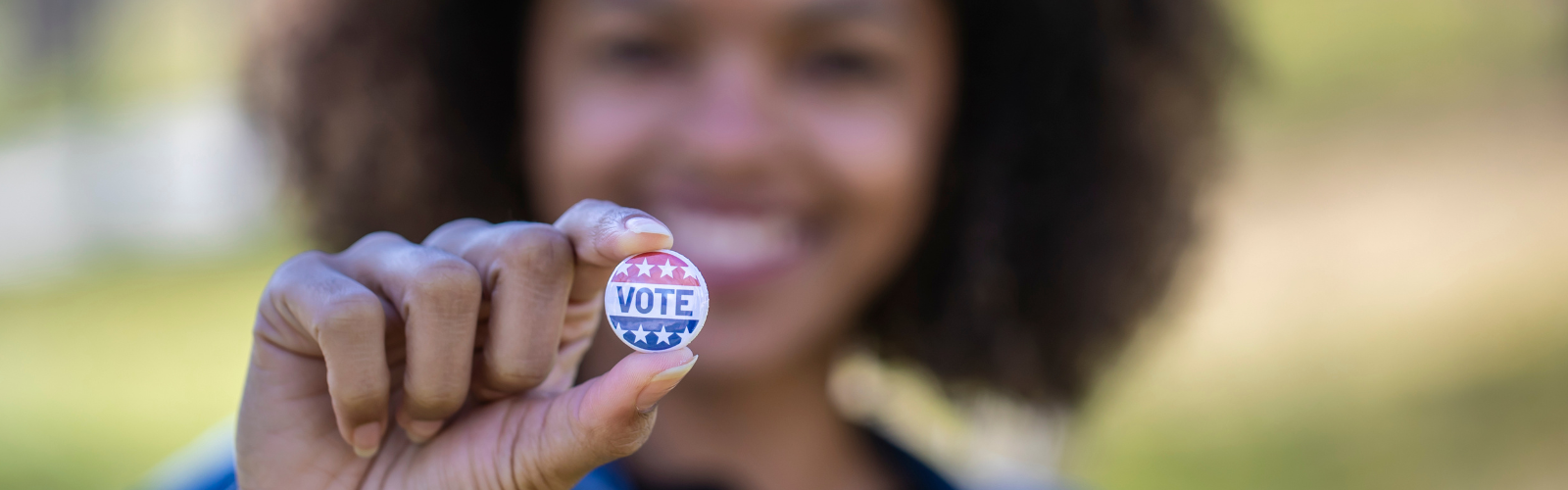 Woman holding "I voted" sticker